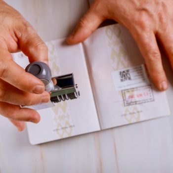 Border control officer puts a stamp in the passport page of passport stamps. Immigration Service control